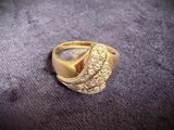 an image of a gold ring sitting on top of a purple cloth