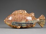a small ceramic fish that is sitting on a table