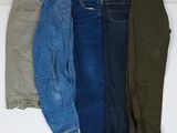 cinq paires de jeans pour homme alignées sur une surface blanche