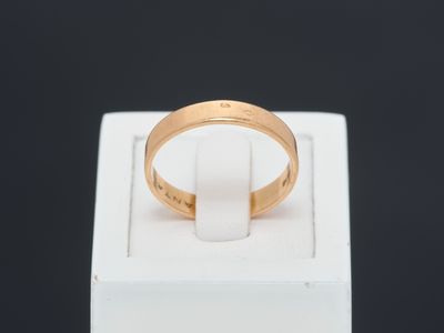 a close up of a gold ring on a white box