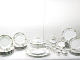 une table sur laquelle se trouvent beaucoup d'assiettes et de bols