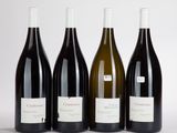 quatre bouteilles de vin sont alignées sur une table
