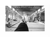 a black and white photo of a person ' s feet in a warehouse