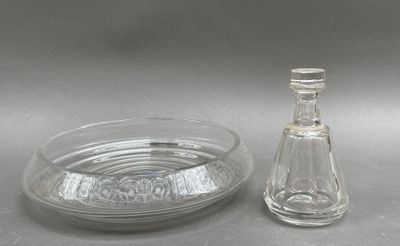 une bouteille en verre et un saladier en verre posés sur une table