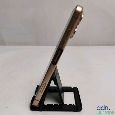 un téléphone portable posé sur un support sur une table