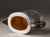a silver cup with a brown inside sitting on a table