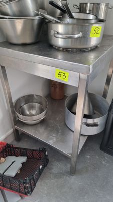 de nombreuses casseroles et poêles posées sur une table en acier inoxydable