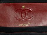 a close up of a red and black purse with a gold logo