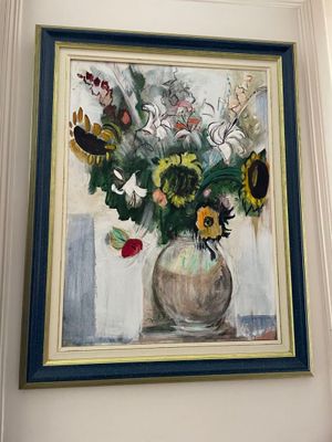 a painting of flowers in a vase hanging on a wall