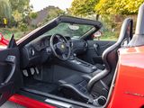 a red sports car with its door open and a steering wheel