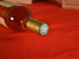 a bottle of wine sitting on a table with a red table cloth