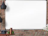 un tableau blanc accroché à un mur de briques, à côté d'une table