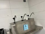 stainless steel sink with five faucets on top of it in a kitchen