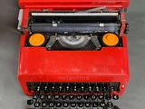 an old red typewriter sitting on top of a table