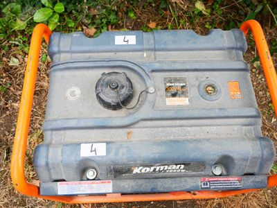 a small portable generator sitting on the ground in the grass