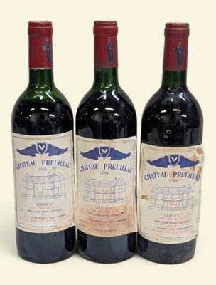 trois bouteilles de vin rouge posées l'une à côté de l'autre sur une surface blanche