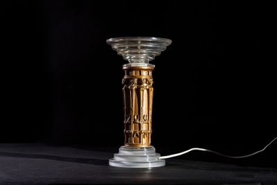 a lamp that is sitting on a table with a black background