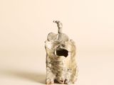 une petite statue représentant un éléphant sur laquelle est perché un oiseau