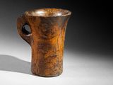 an old wooden cup sitting on top of a table next to another cup