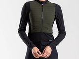 the woman is wearing a black and green jacket and leggings
