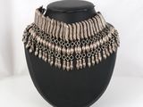 un collier noir orné de perles argentées sur un mannequin noir