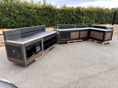 Plusieurs meubles sont empilés sur des palettes dans un parking