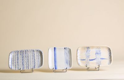 trois petites assiettes ornées de motifs bleus et blancs, posées sur une table
