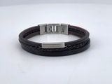 a close up of a leather bracelet on a white surface