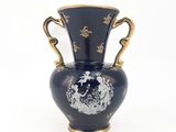 un vase bleu avec une anse dorée sur fond blanc