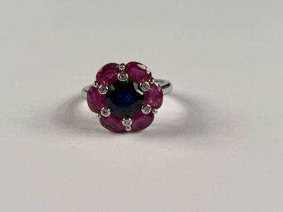 gros plan d'une bague avec une pierre bleue entourée de diamants blancs