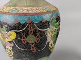 a black vase with a colorful design on it