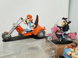 three figurines of people riding motorcycles on a table