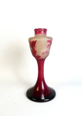 un vase rouge posé sur un socle noir