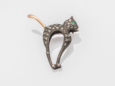 un gros plan d'une broche en forme de chat posée sur une surface blanche