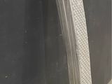 a large piece of metal leaning against a black wall