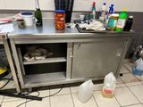 un plan de travail en acier inoxydable sur lequel sont posés tout un tas de produits d'entretien
