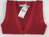 Le pull est rouge et porte une étiquette blanche.