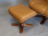 a brown leather chair and ottoman on a white background