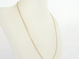 a white mannequin torso with a gold chain on it