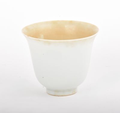 a white cup with a brown rim on a white background
