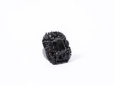 a close up of a black stone ring on a white surface