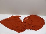 a red shirt laying on a white table next to a white wall
