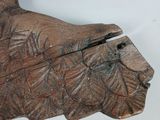 a wooden carving of a bird on a white surface