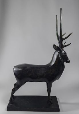 une sculpture en bronze représentant un cerf accompagné d'une antilope, posée sur un socle noir