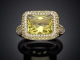 a yellow sapphire and diamond ring on a black surface