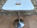 a white table with a card on it on a brick floor