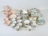 many different types of tea cups and saucers on the table