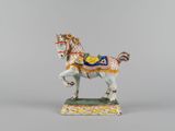 porcelain figurine of a horse with a saddle on it ' s back