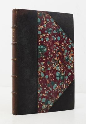un vieux livre orné d'un motif floral, posé sur une surface blanche