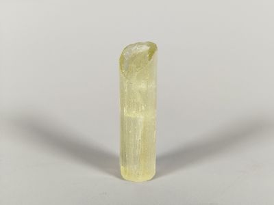 a close up of a piece of yellow quartz on a white surface